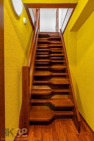 Holztreppen und gelbe Wände in einer Wohnung mit 5 oder mehr Zimmern.