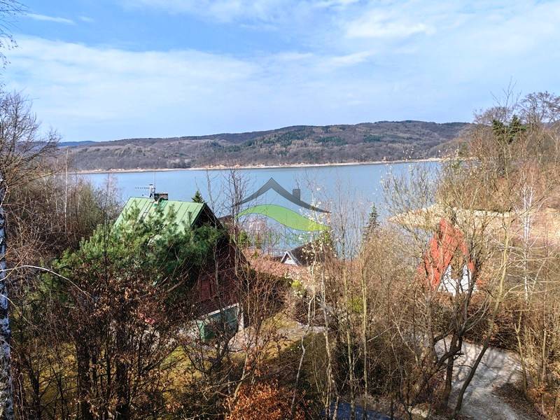Blick von der Hütte in Holčíkovce auf das Zajačia Debra mit dem See und den Wäldern im Hintergrund.