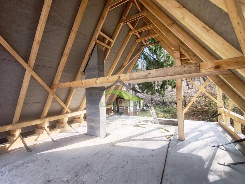 Interieur der Hütte mit Dachkonstruktion und Blick auf die äußere Natur.