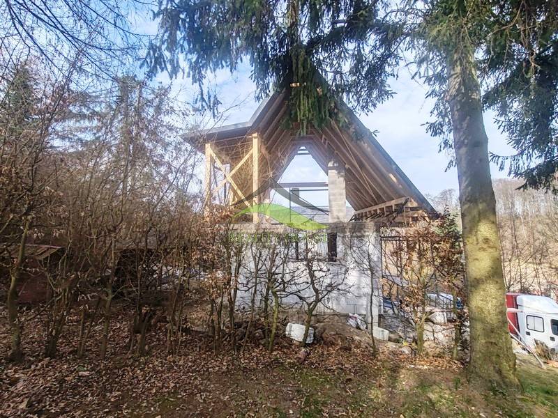 Der Bau der Hütte auf dem Zajačia debra in Holčíkovce, umgeben von Wald und Grün.