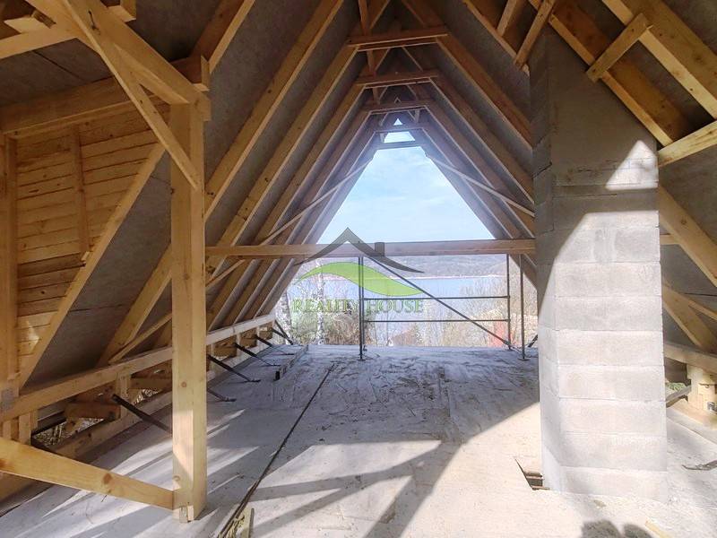 Innenraum einer im Bau befindlichen Hütte mit Blick auf die Natur, Boden mit Holzdekor.