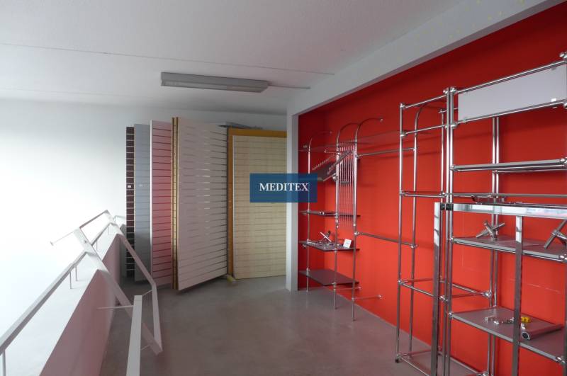Geschäft mit Metallregalen und -ständern in Geschäftsräumen.