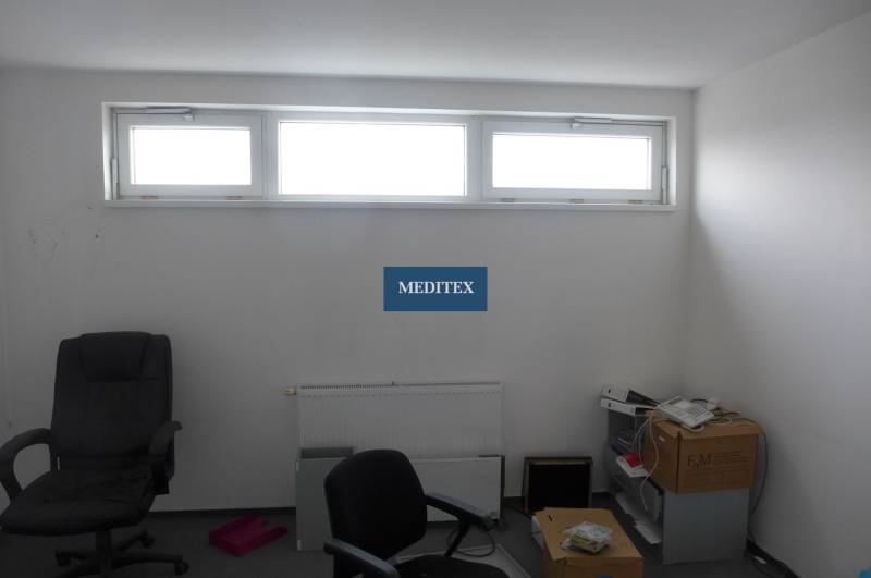 Ein Raum mit einem Fenster und Bürostühlen in Geschäftsräumen.