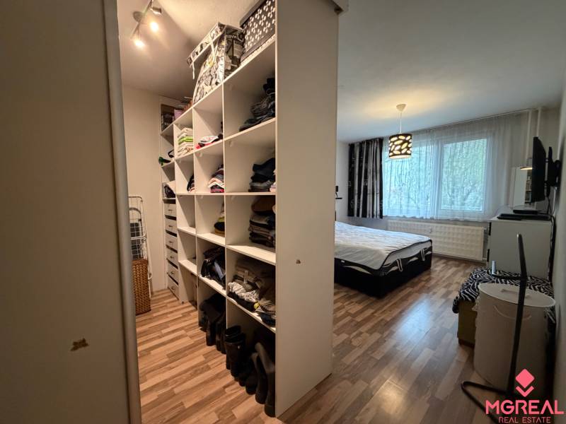 Schlafzimmer in einer 3-Zimmer-Wohnung mit Stauraum und Bodenbelag in Holzoptik.