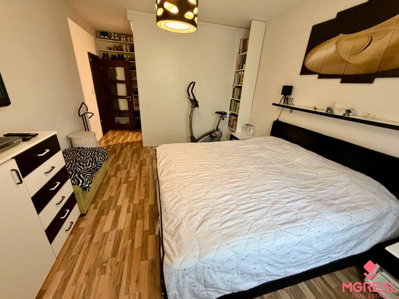 Schlafzimmer mit Doppelbett und Holzboden in einer 3-Zimmer-Wohnung.