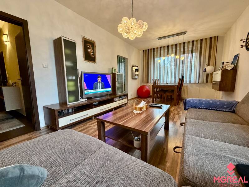 Wohnzimmer in einer 3-Zimmer-Wohnung mit Holzboden und einem bequemen Sofa.