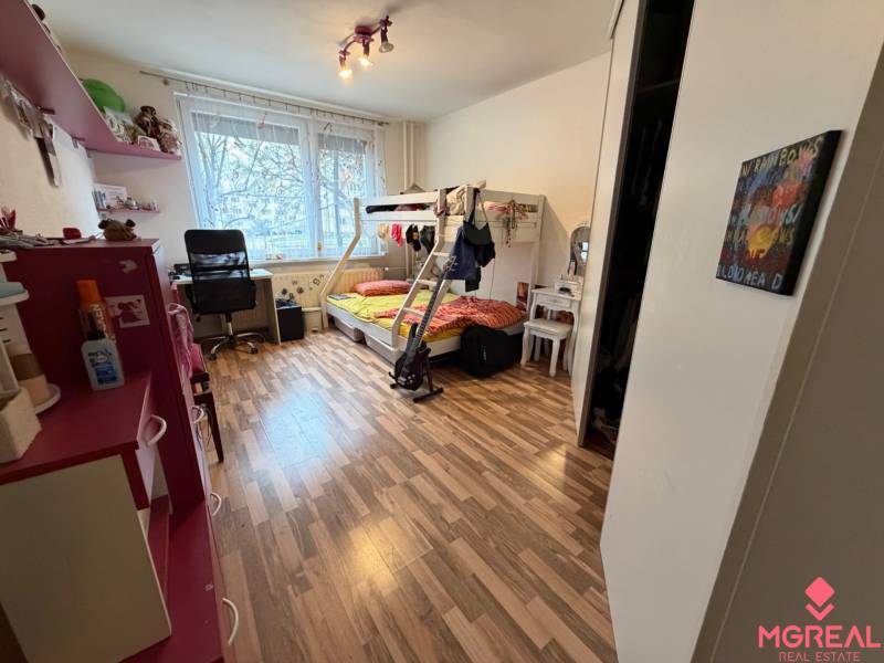 Kinderzimmer mit Holzboden, Etagenbett und Schreibtisch.