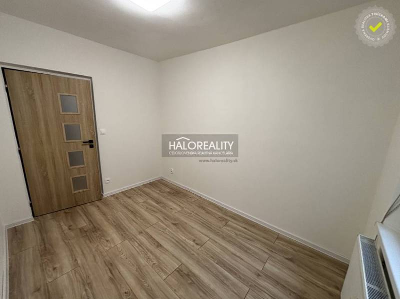 Ein Zimmer mit weißen Wänden und einem Boden in Holzoptik in einer 3-Zimmer-Wohnung.