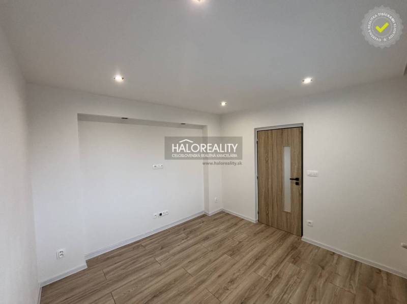 Ein geräumiger Raum mit Holzboden und eingelassener Beleuchtung in einer 3-Zimmer-Wohnung.