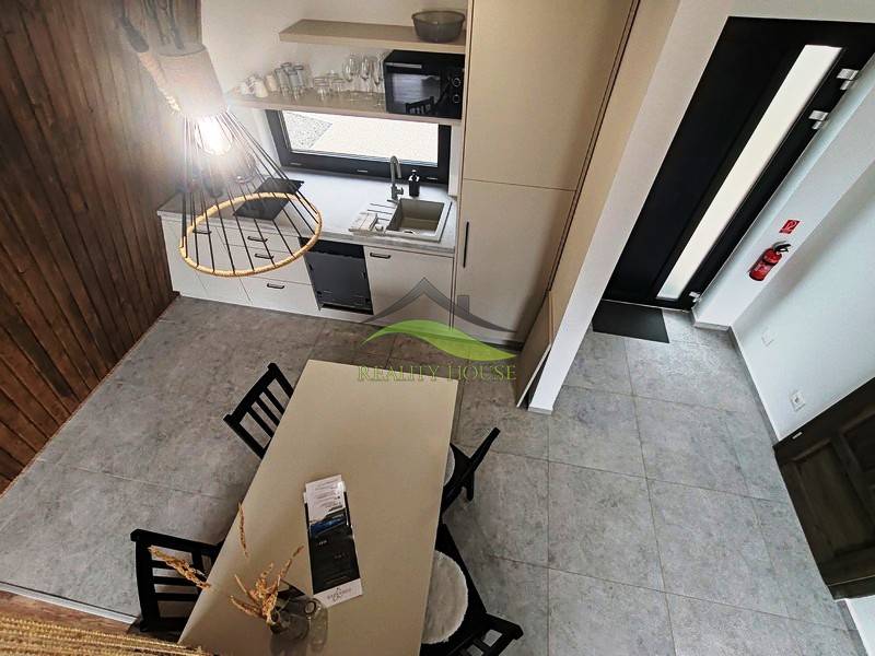 Das Innere der Hütte mit Esstisch, Küchenzeile und Holzboden-Dekor.