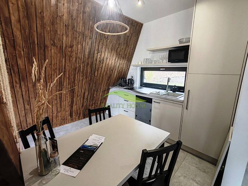 Eine Küche in einer Hütte mit Holzboden, Holzwänden und moderner Ausstattung.