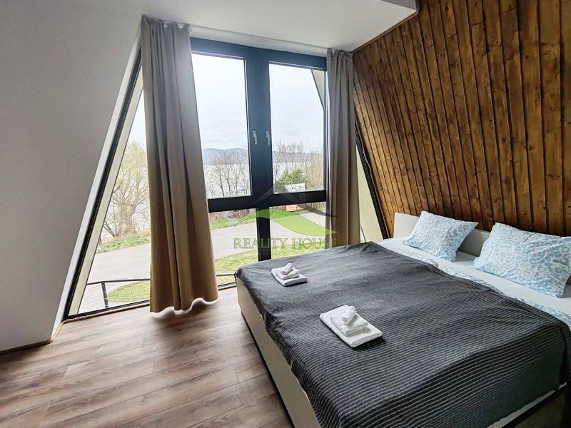 Ein Zimmer in einer Hütte mit Aussicht, einem Bett und einem Boden mit Holzdekor.