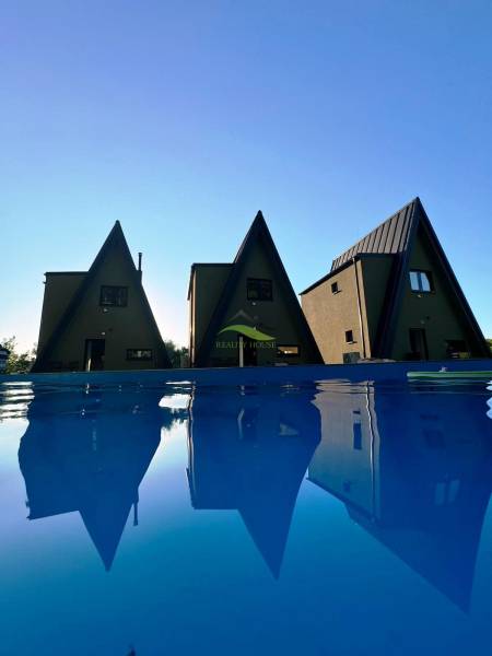 Häuser auf der Eva-Straße in Holčíkovce am Pool mit blauer Wasseroberfläche.