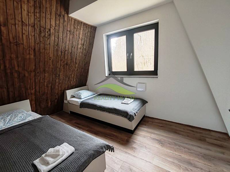 Ein Zimmer mit zwei Betten, Holzverkleidung und einem Boden mit Holzdekor in einer Hütte.