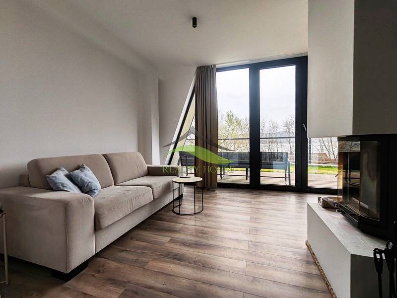 Wohnzimmer in einer Hütte mit Kamin, Sofa und Holzboden.