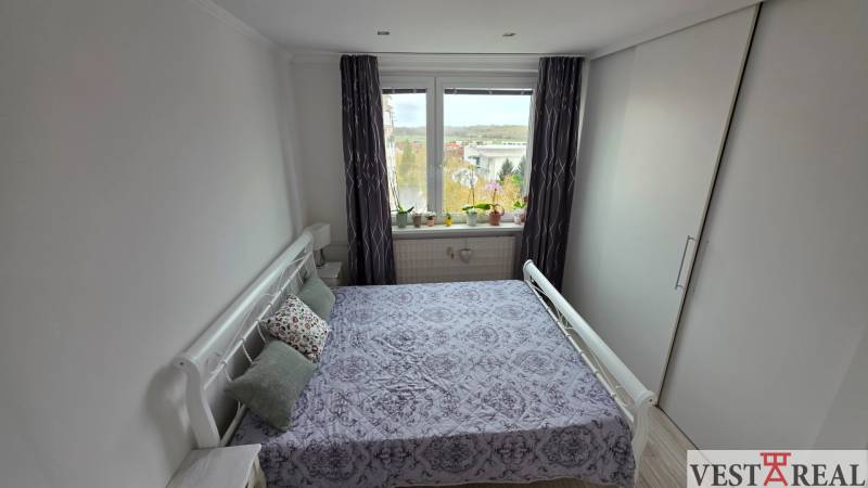 Schlafzimmer in einer 3-Zimmer-Wohnung mit großem Fenster und Einbauschrank.