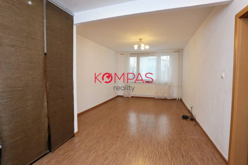 Wohnzimmer mit Vorhängen und Holzboden in einer 3-Zimmer-Wohnung.