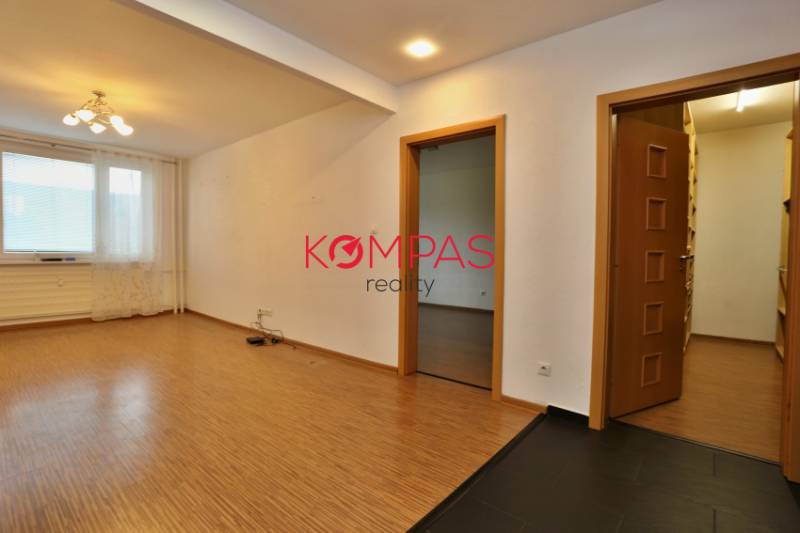 Wohnzimmer in einer 3-Zimmer-Wohnung mit Holzboden und Blick aus dem Fenster.