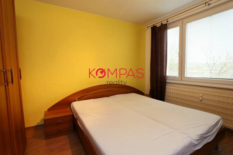 Schlafzimmer in einer 3-Zimmer-Wohnung mit viel Licht und einem Boden in Holzoptik.