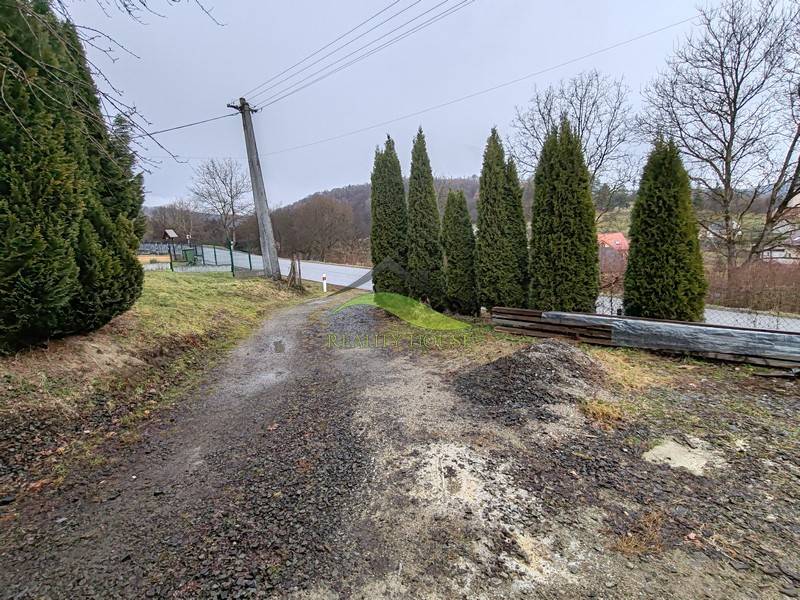 Straße und Bäume neben dem Einfamilienhaus in der Hauptstraße in Piskorovce.