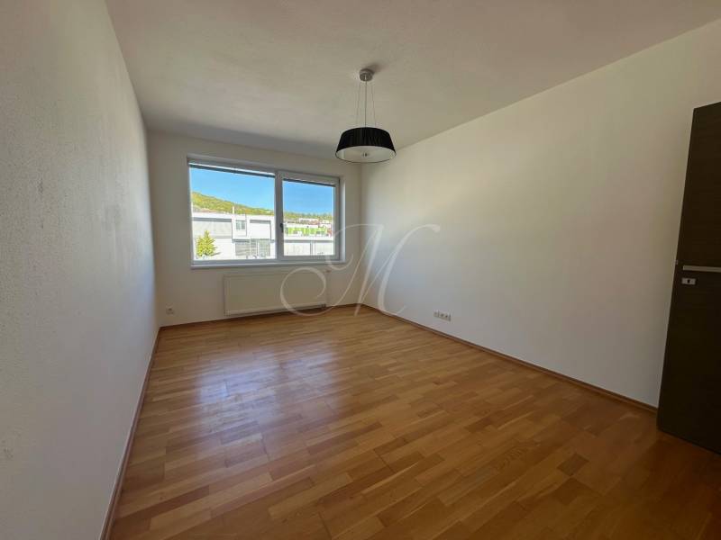 Ein geräumiges Zimmer in einer 4-Zimmer-Wohnung mit Holzboden und einem großen Fenster.