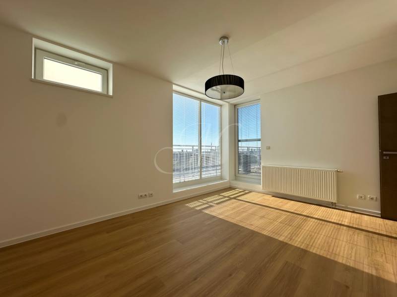 Helles Zimmer mit Holzboden in einer 4-Zimmer-Wohnung, große Fenster, Heizkörper.