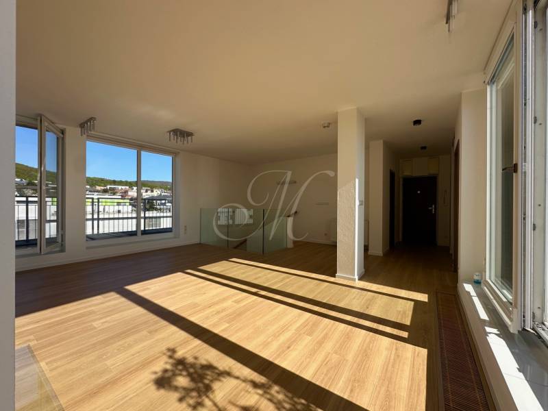 Wohnzimmer in einer 4-Zimmer-Wohnung mit Holzboden und großen Fenstern.