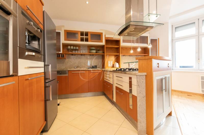 Küche in einer 4-Zimmer-Wohnung mit Holzelementen und Edelstahlgeräten.