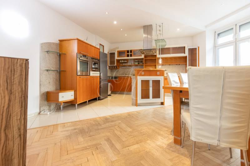 Küche in einer 4-Zimmer-Wohnung mit Holzboden und eingebauten Geräten.