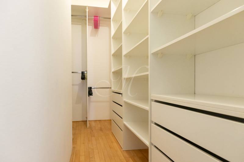 Ein Kleiderschrank mit Regalen und Schubladen, ein Boden mit Holzdekor, eine 4-Zimmer-Wohnung.