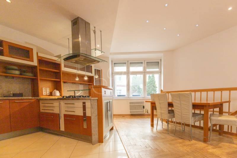 Küche mit Essecke in einer 4-Zimmer-Wohnung, Boden mit Holzdekor, weiße Wand.