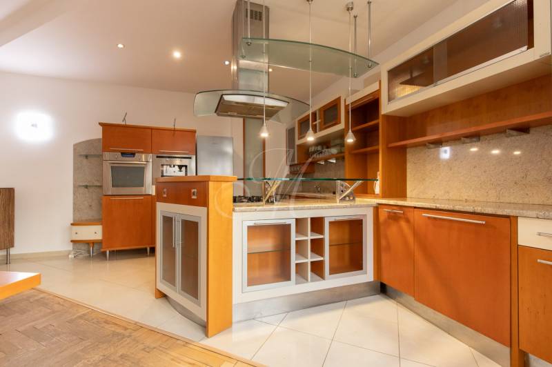 Küche in einer 4-Zimmer-Wohnung mit Insel und Boden in Holzoptik.