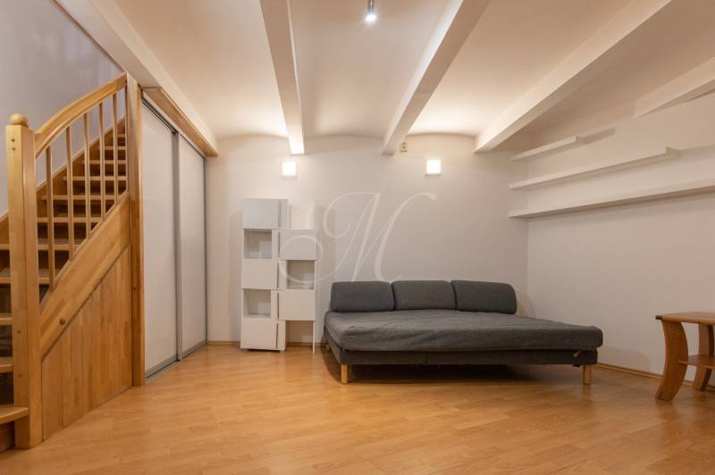 Wohnzimmer mit Sofa, Treppe und Holzboden in einer 4-Zimmer-Wohnung.