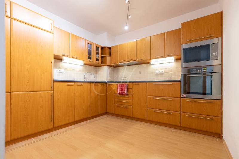 Küche in einer 2-Zimmer-Wohnung mit Holzboden und Einbaugeräten.