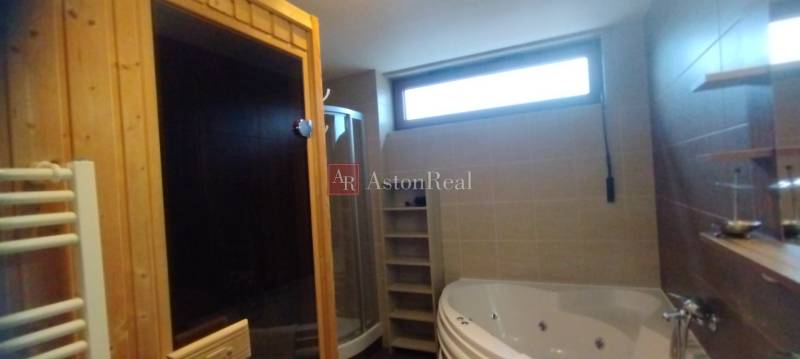 Badezimmer in einer 2-Zimmer-Wohnung mit Sauna, Dusche und Whirlpool.