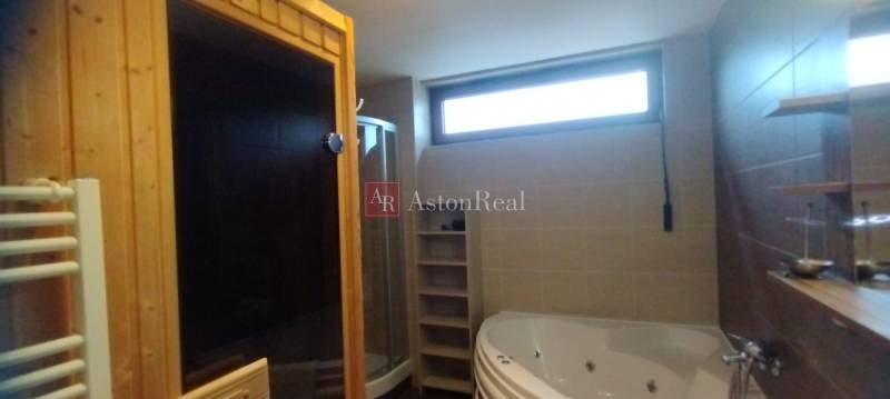 Badezimmer mit Badewanne, Dusche, Sauna und Fenster in einer 2-Zimmer-Wohnung.