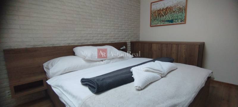 Schlafzimmer mit Holzmöbeln und einem Bild, Boden mit Holzdekor, 2-Zimmer-Wohnung.
