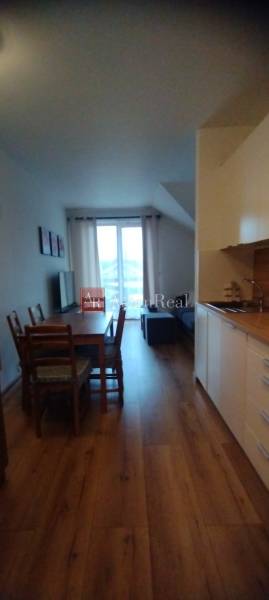 Küchenzeile mit Esstisch und Holzboden in einer 2-Zimmer-Wohnung.