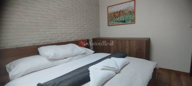 Schlafzimmer in einer 2-Zimmer-Wohnung mit Bett und Schrank, Boden mit Holzdekor.