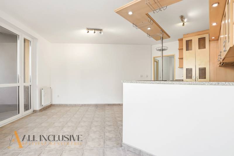 Die Küche in einer 2-Zimmer-Wohnung mit gefliestem Boden und Holzschränken.