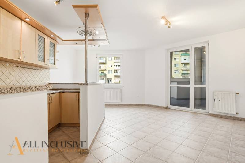 Küche mit Bartresen und Fliesenboden in einer 2-Zimmer-Wohnung.