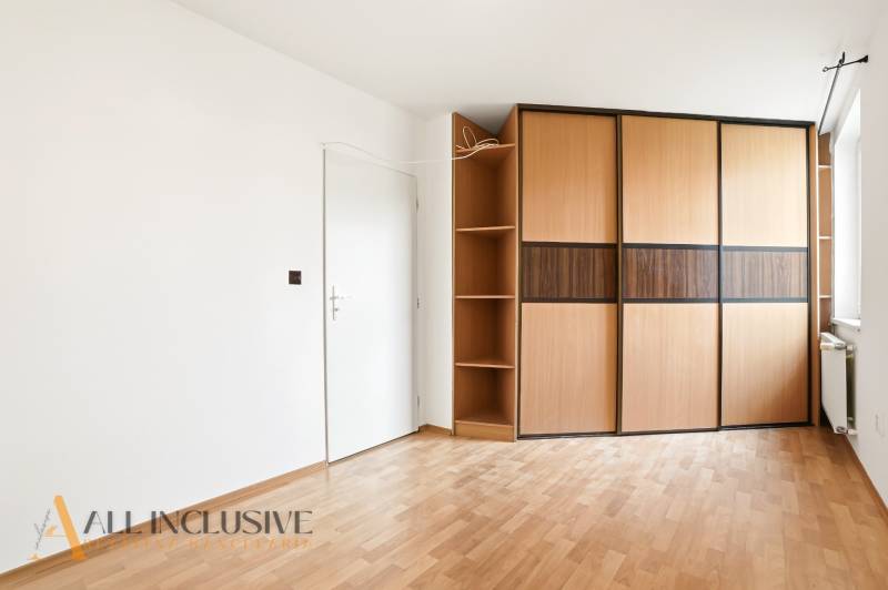 Weißes Interieur mit großem Schrank und Holzboden in einer 2-Zimmer-Wohnung.