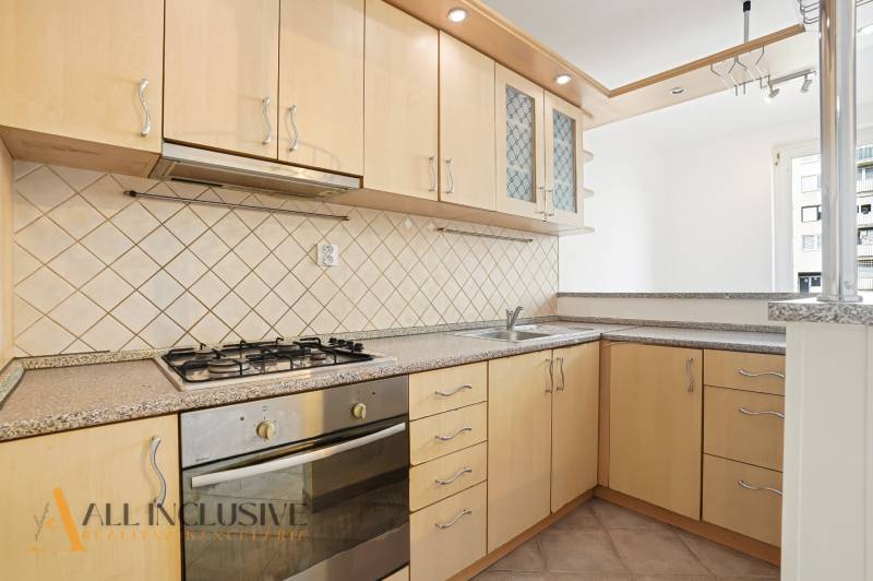 Küche in einer 2-Zimmer-Wohnung mit einem Gasherd und hellen Küchenschränken.