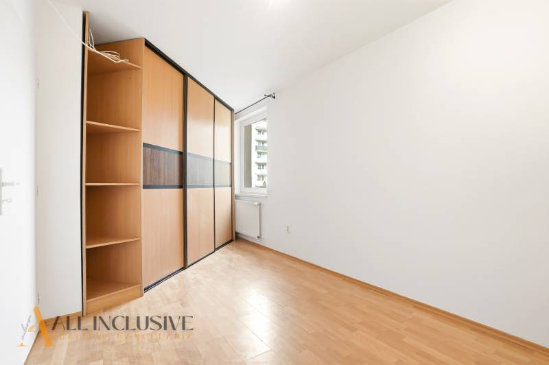 Ein Zimmer in einer 2-Zimmer-Wohnung mit einem Boden in Holzoptik und einem Einbauschrank.