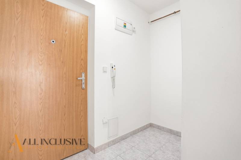 Eingangsbereich mit weißen Wänden und Fliesen in einer 2-Zimmer-Wohnung.