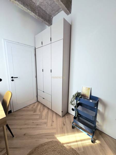 Ein stilvolles Eck in einer 3-Zimmer-Wohnung mit einem Holzboden und einem Aufbewahrungsregal.