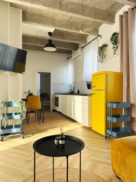 Innenraum einer 3-Zimmer-Wohnung mit Holzboden, gelbem Kühlschrank und weißer Küchenzeile.