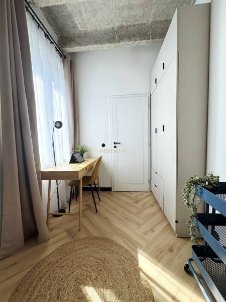 Der Holzboden, der Schreibtisch und der hohe weiße Schrank dominieren in der 3-Zimmer-Wohnung.