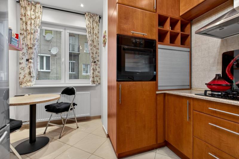 Küche in einer 3-Zimmer-Wohnung mit Essecke und Holzdekor der Schränke.