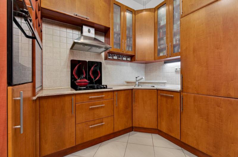 Küche in einer 3-Zimmer-Wohnung mit Holzmöbeln und eingebauten Geräten.